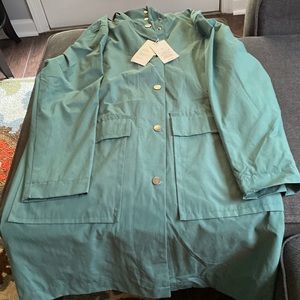 Size medium , green to the knee  trench coat with hood snd two large pockets.